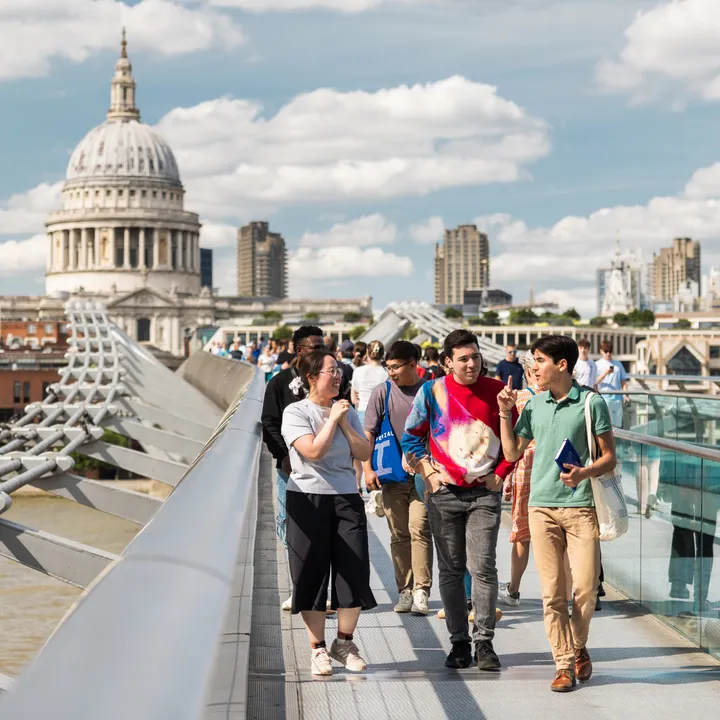 Students walking on the Millennium Bridge in London with St Paul's Cathedral in the background