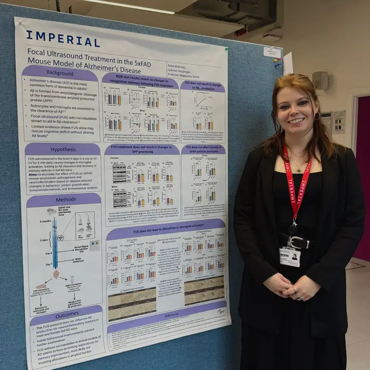 Anita standing with a poster of her work