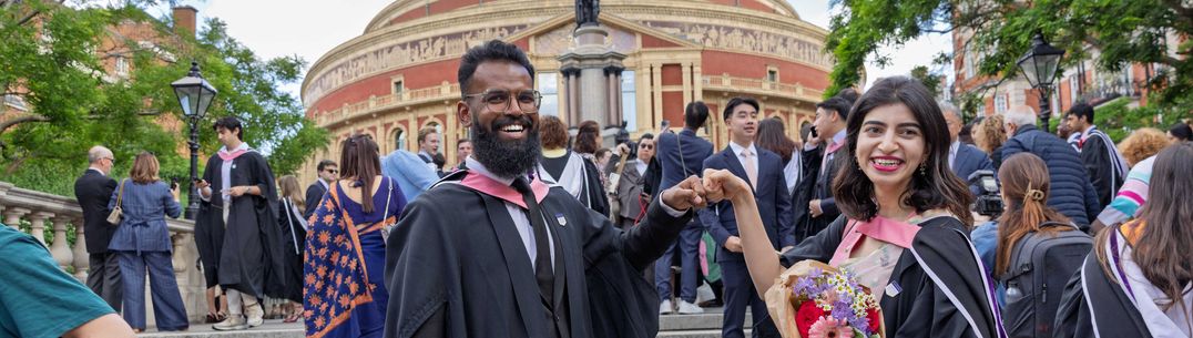 Two graduates cheering on graduation day