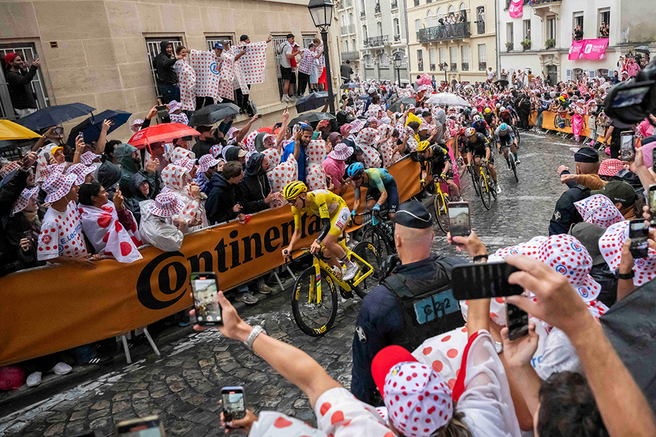 Yellow Jersey overall leader Slovenian rider Tadej Pogacar of UAE Team Emirates is cheered by spectators as the cyclists ride through Paris' Montmartre district where the 21st and last stage of the Tour de France cycling race