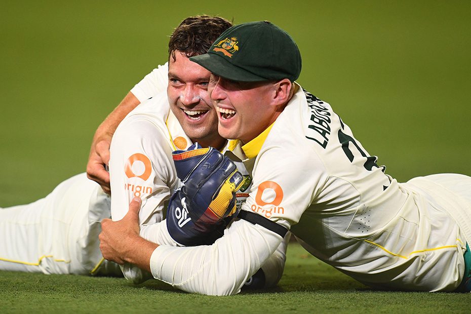 Alex Carey of Australia celebrates taking a catch with team mate Marnus Labuschagne during Day one of the Second Men's Ashes Test between Australia and England at The Gabba in Brisbane