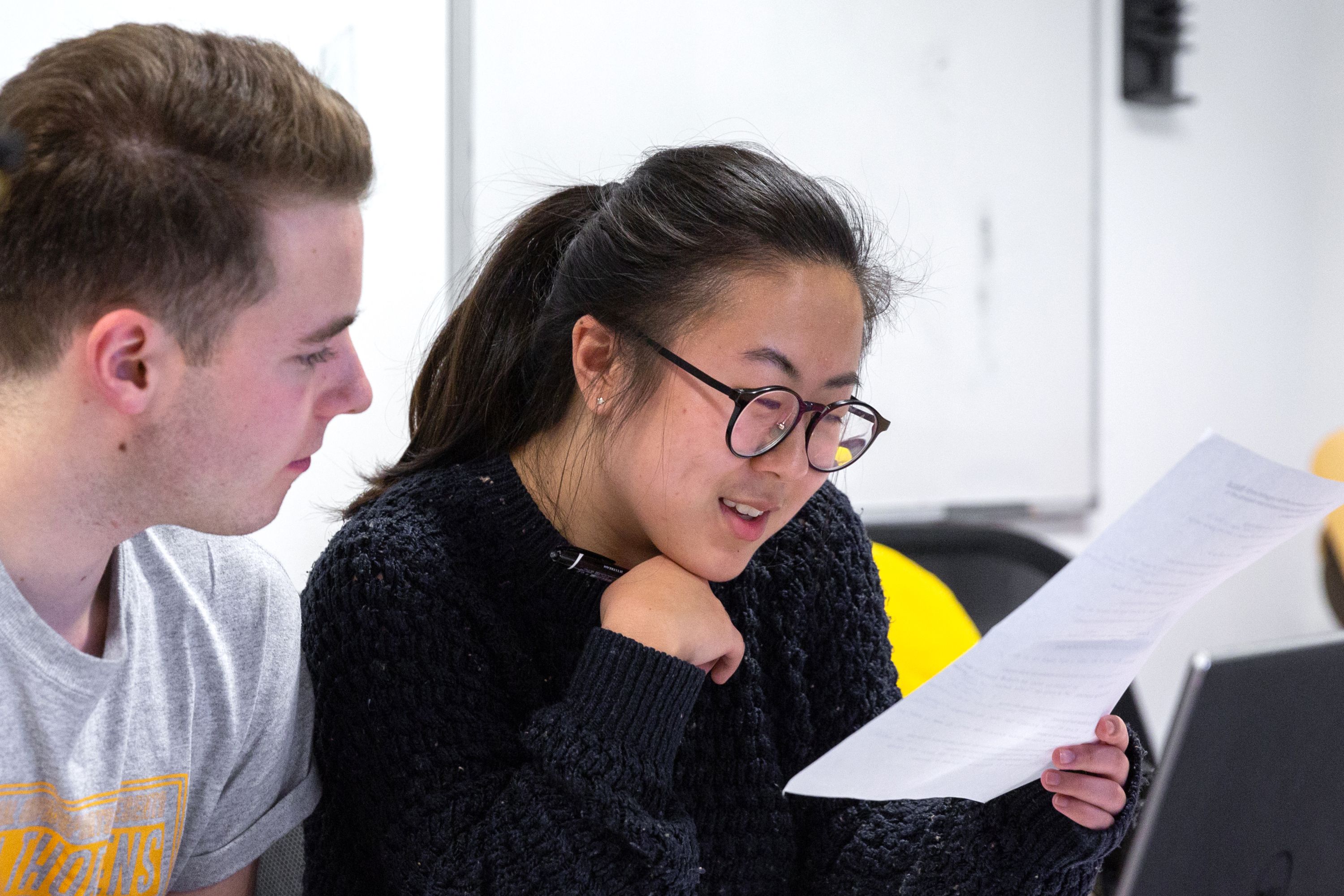 Two students looking at a piece of paper