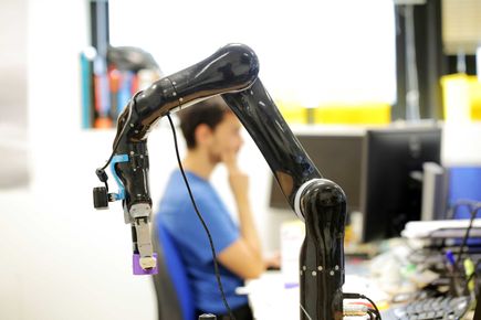 Close up of robotics tech and person in the background