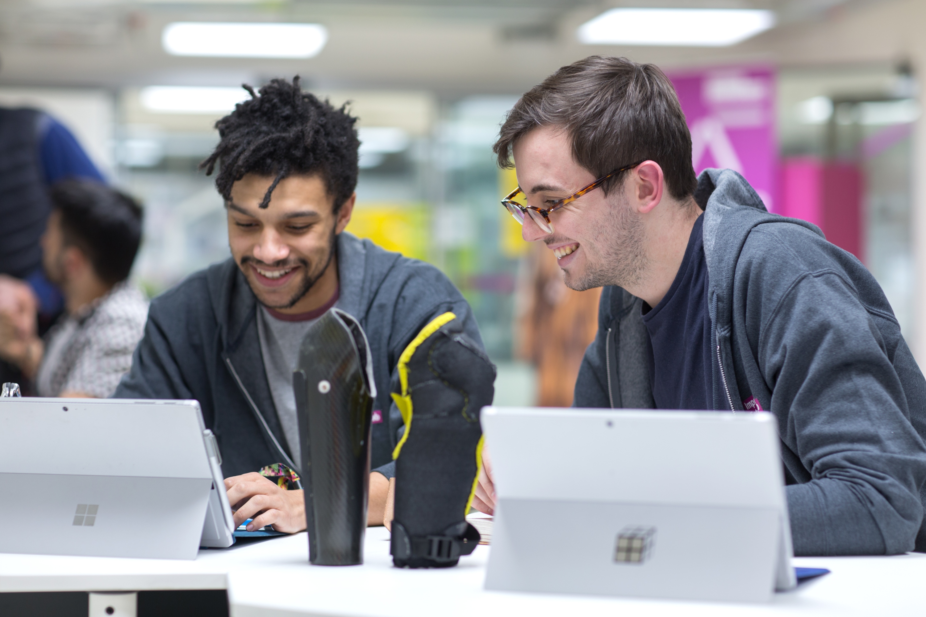 Two male students sat looking at iPads