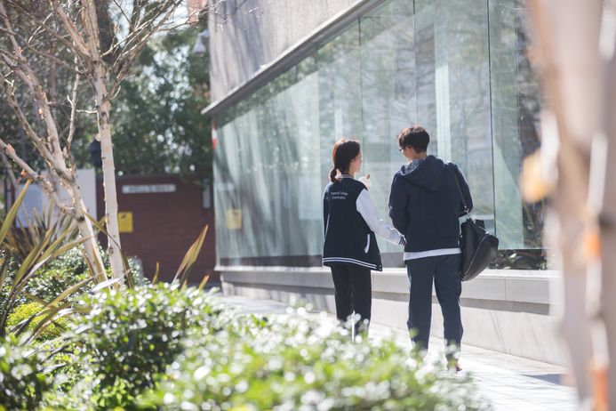 Two students walking on campus with an ice cream
